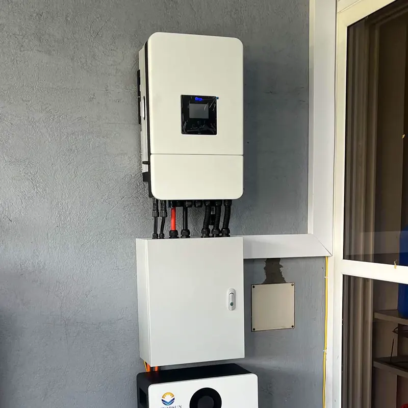 Hybrid inverter above its protection enclosure and a battery