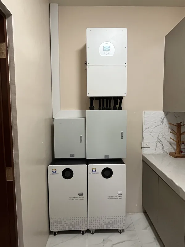 Hybrid inverter, two protection enclosures and two battery cabinets in a white room